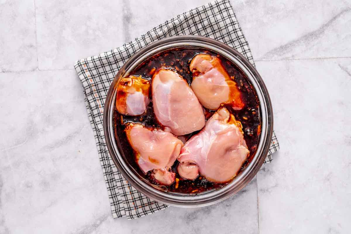 raw chicken thighs soaking in the marinade.