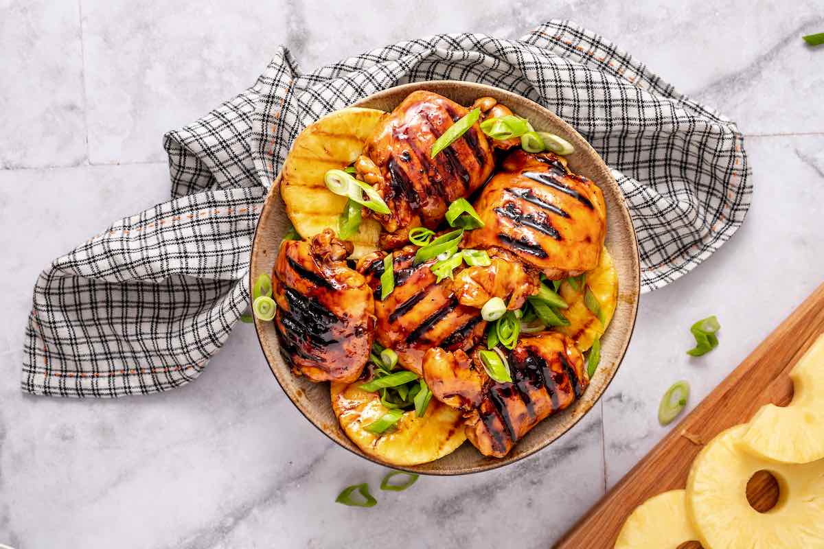 grilled huli huli chicken with sliced pineapple and green onion.