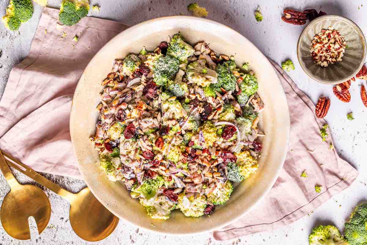 dressing mixed with broccoli salad in a bowl.