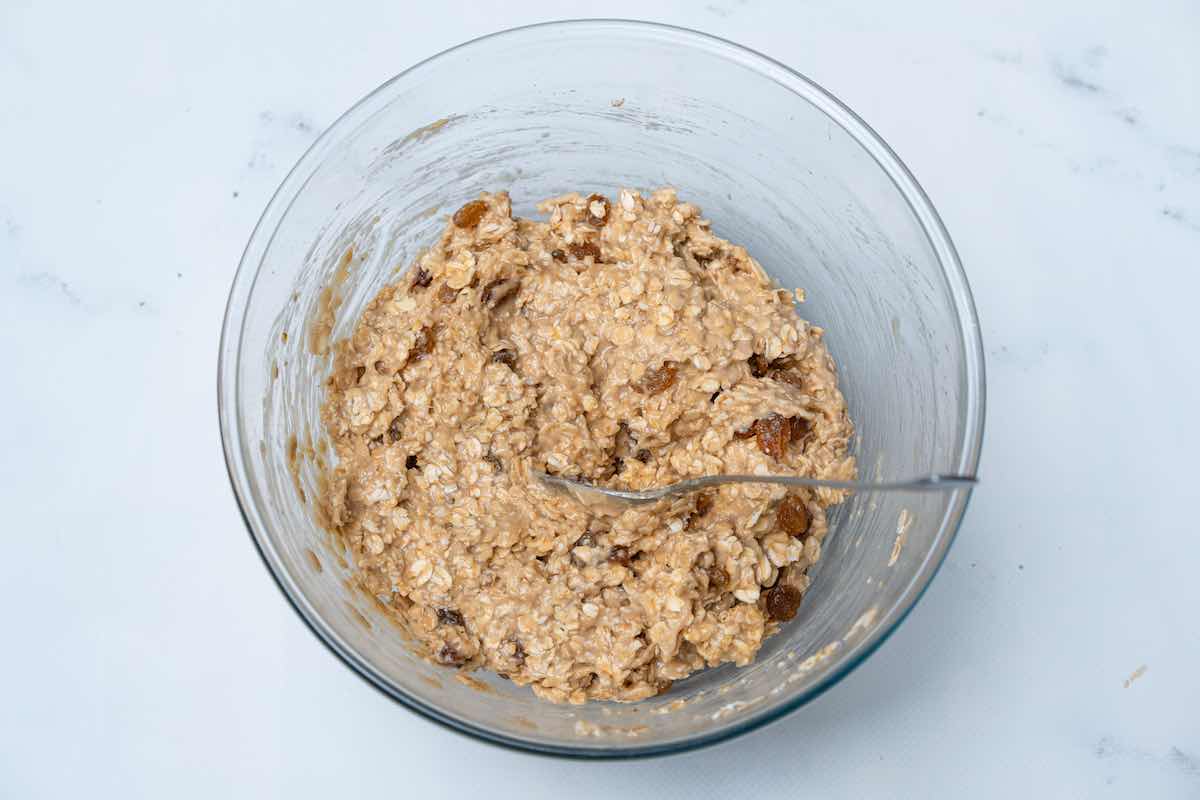oats, maple syrup, almond butter, raisins, and banana in a bowl.