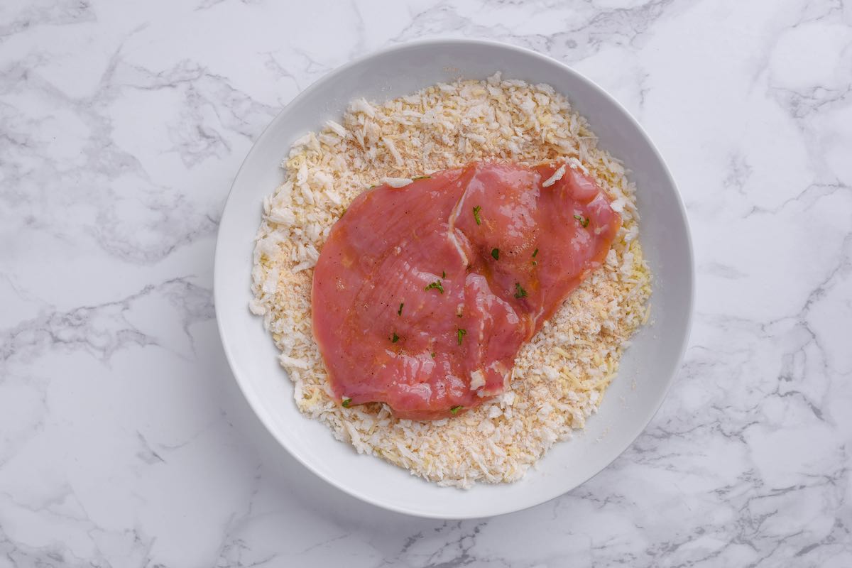 breading raw veal cutlets.