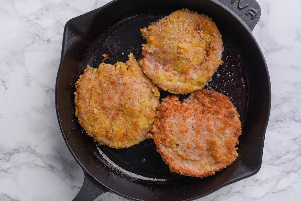 pan-fried veal cutlets in a skillet.