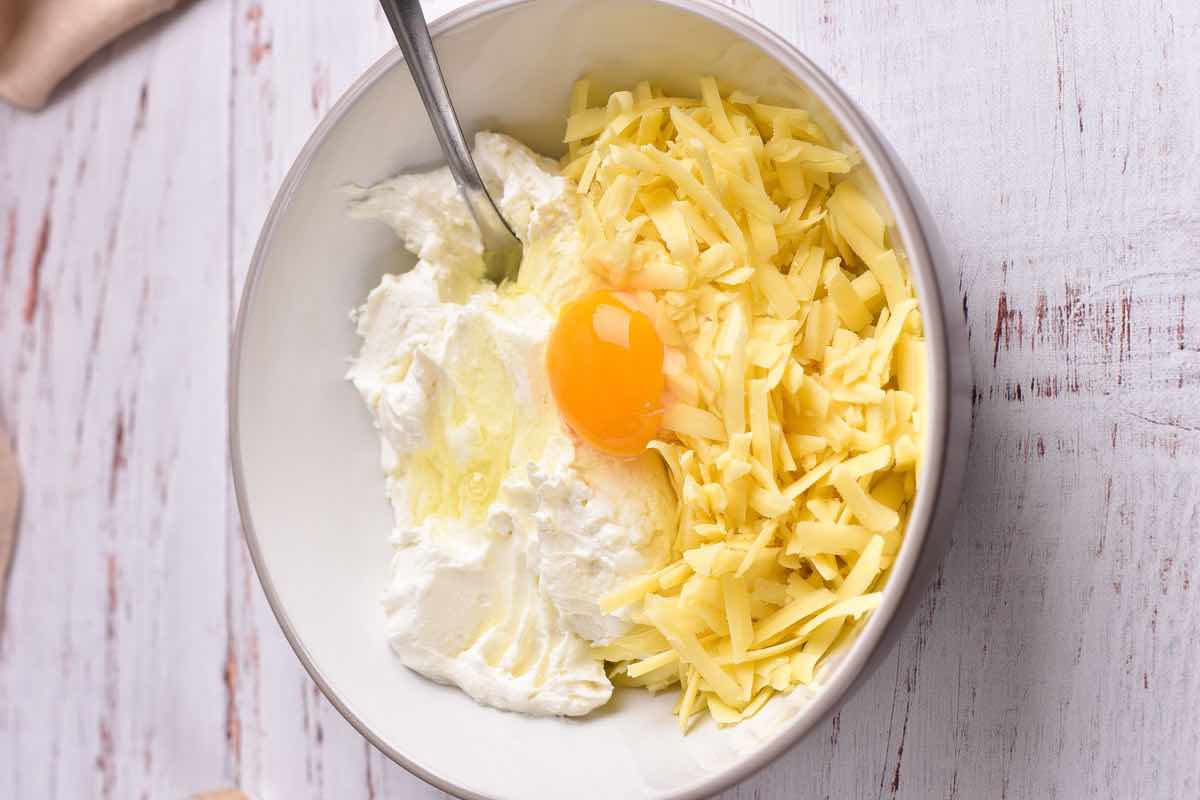 ricotta cheese, egg, and shredded cheese in a bowl.