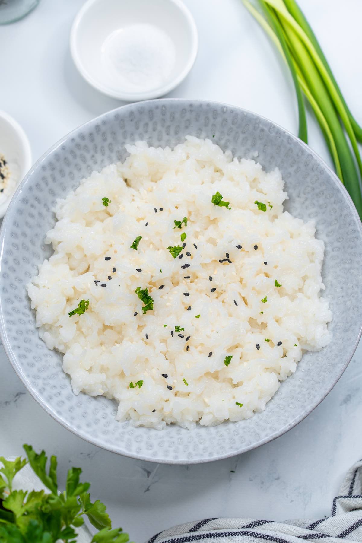 Instant Pot Sushi rice in a bowl with black sesame seeds on top.