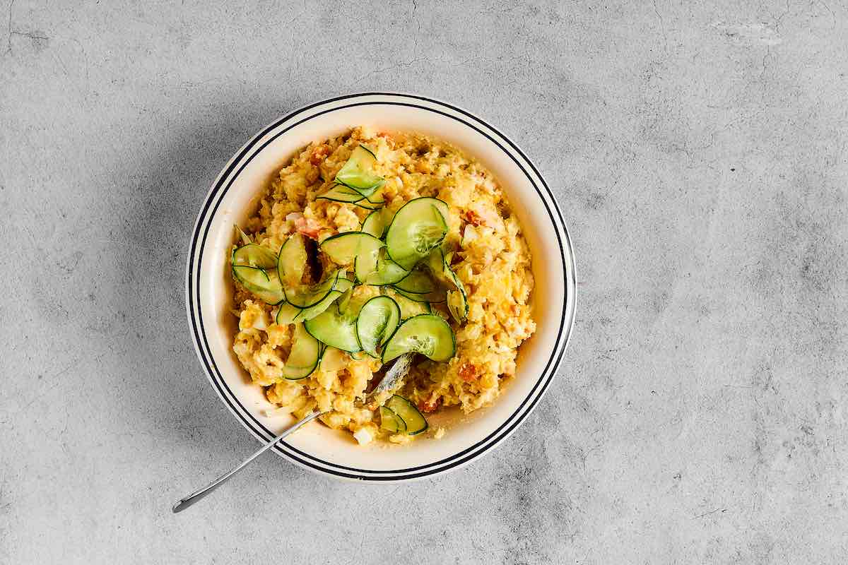 assembled Japanese potato salad with sliced cucumbers on top.