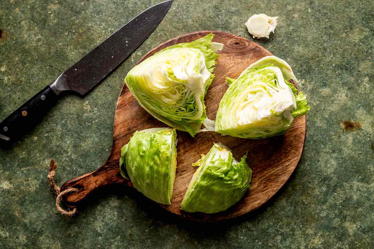 quartered lettuce on a chopping board.