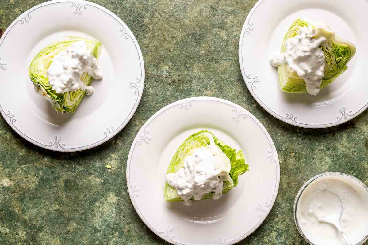 wedges of lettuce with blue cheese dressing on top.