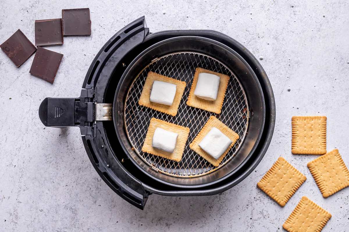 graham crackers with halved marshmallows in the air fryer basket.