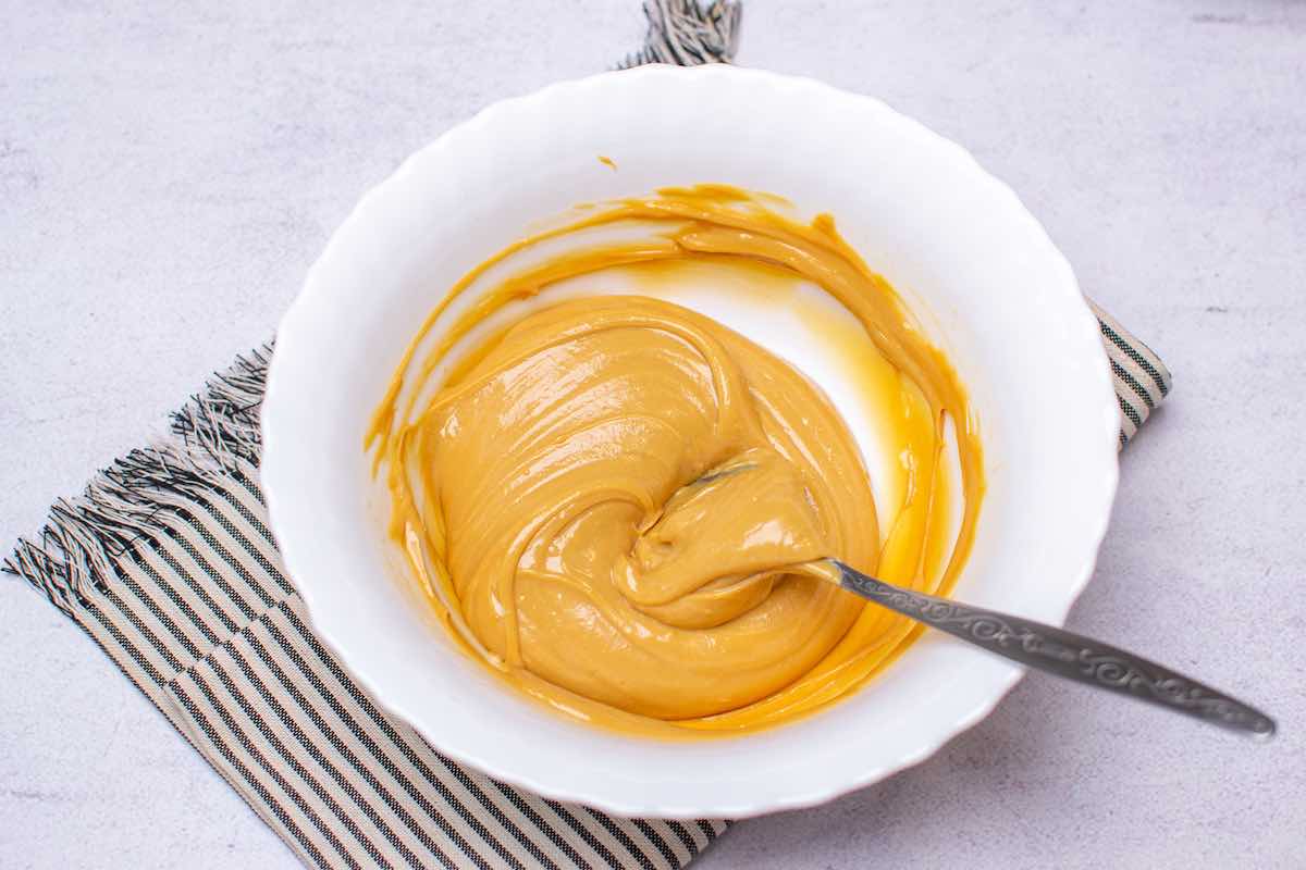 almond butter, maple syrup, and coconut flour whisked together in a bowl.
