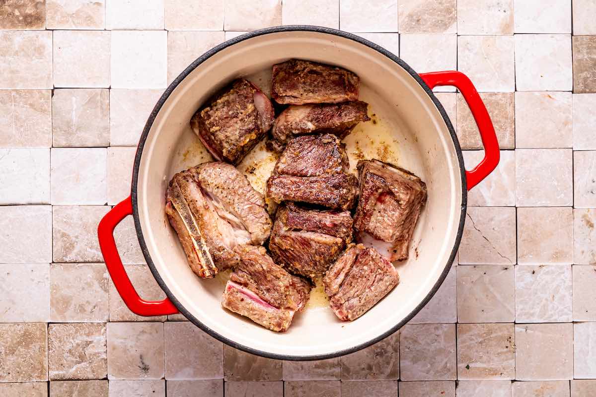 searing beef chuck short ribs in a Dutch oven.