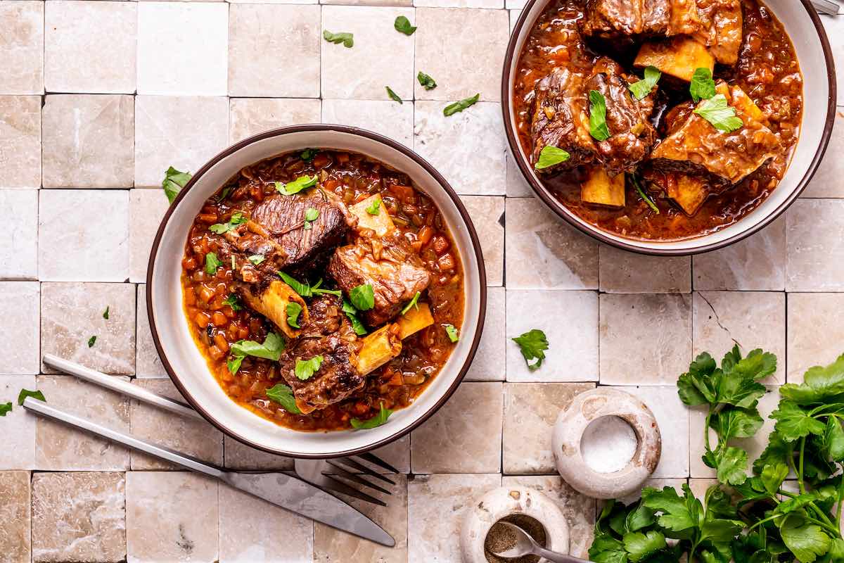 bowls of beef chuck short ribs with beans, rice, and fresh herbs.