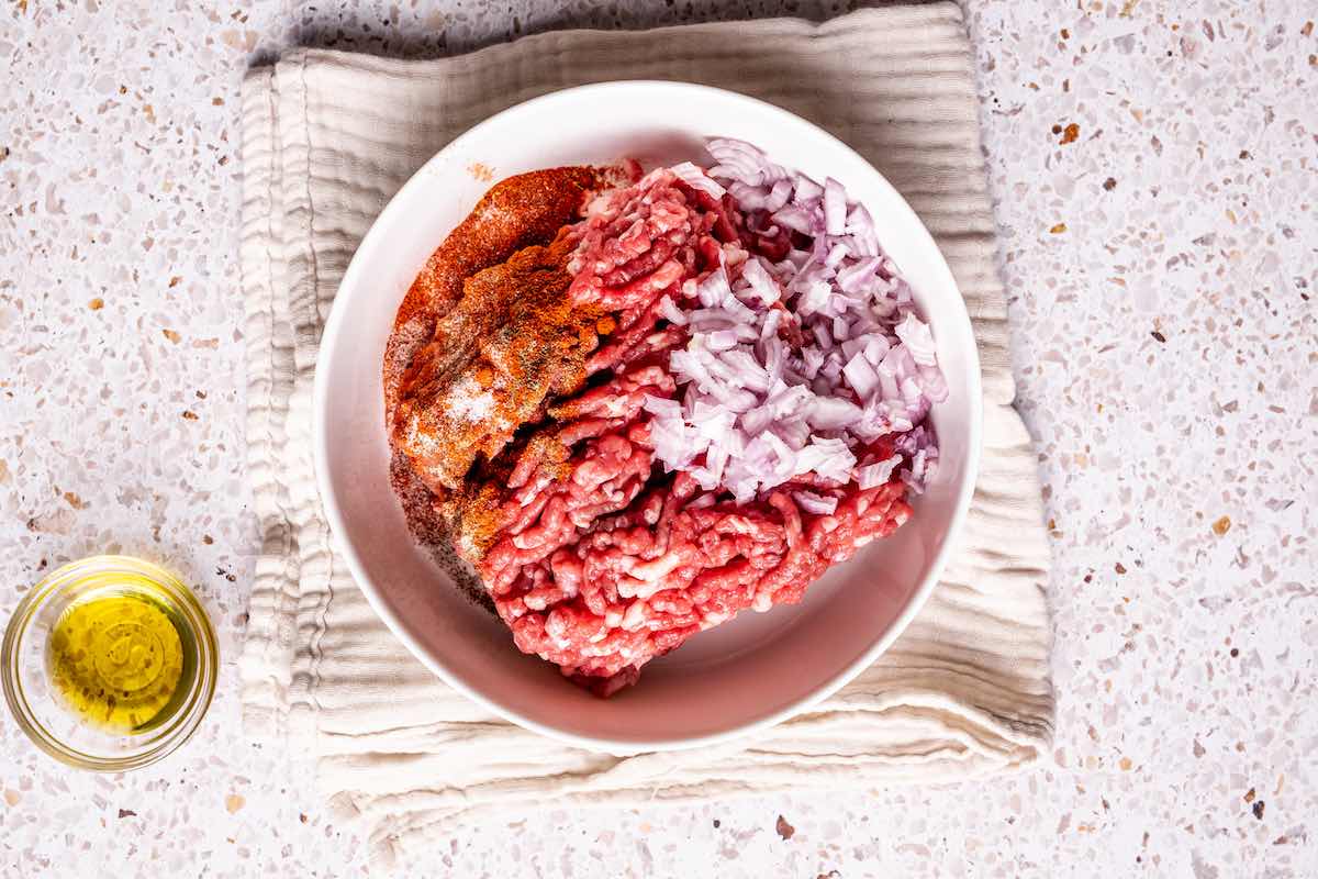 ground bison, onion, smoked paprika, and salt in a bowl.