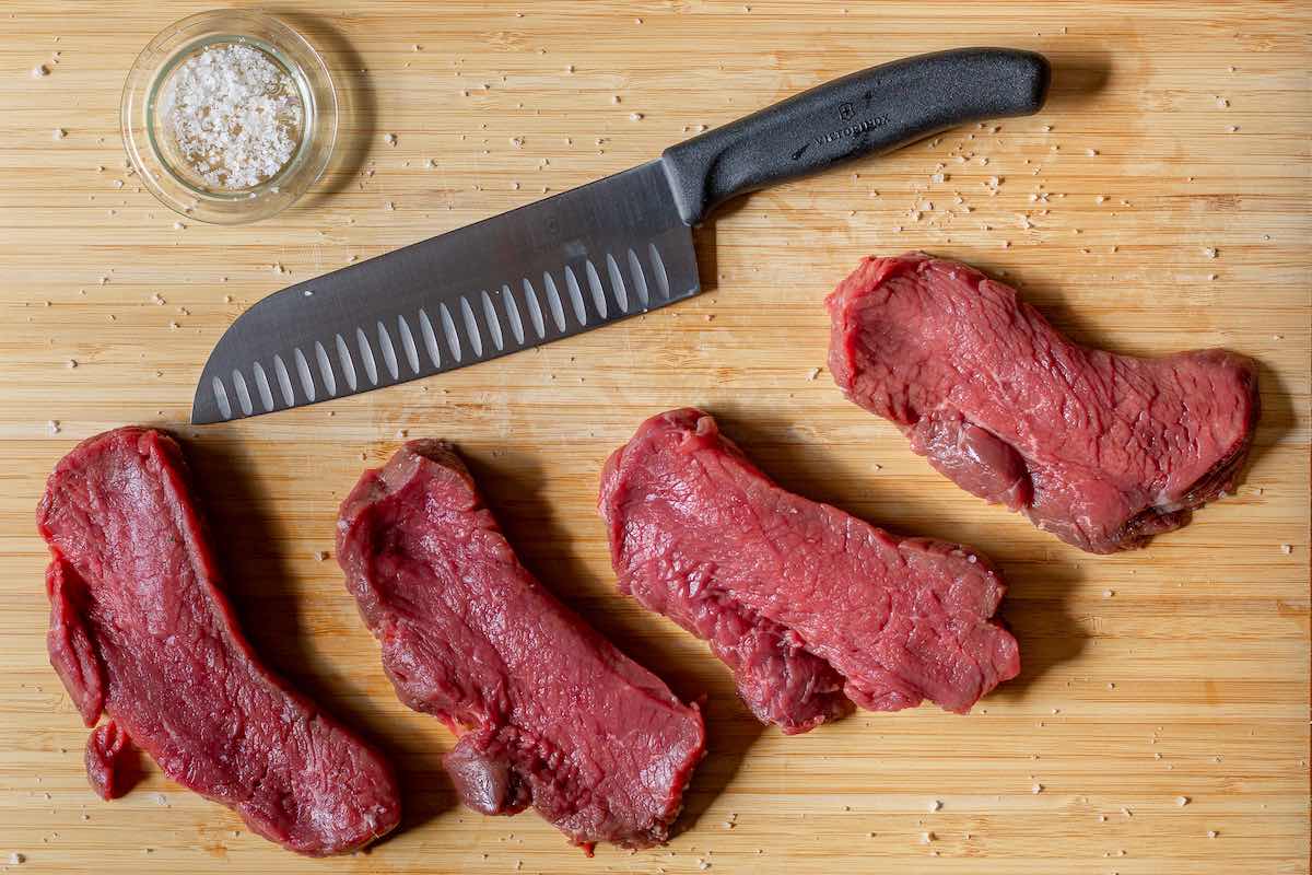 raw flank steak with butter, salt, and pepper.
