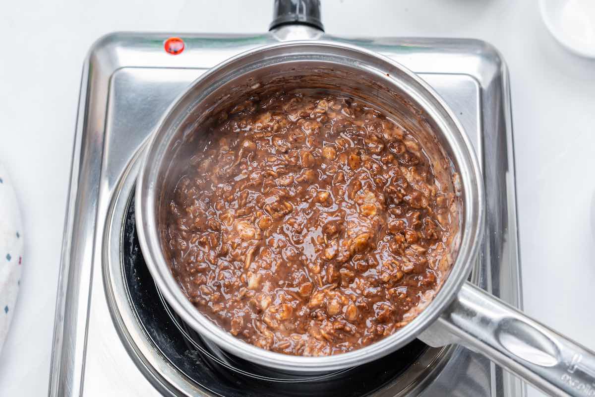 adding cocoa powder and hot chocolate mix to oatmeal.
