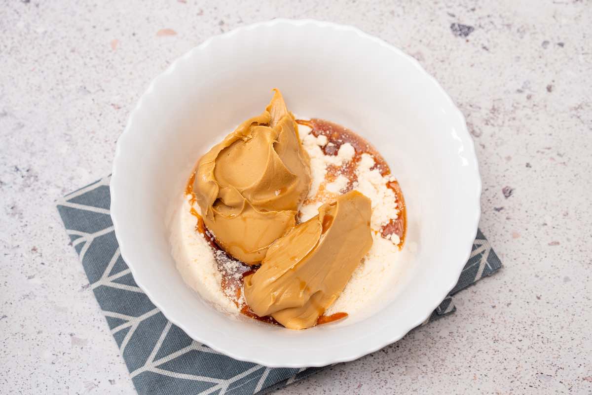 peanut butter, maple syrup, and coconut flour in a bowl.