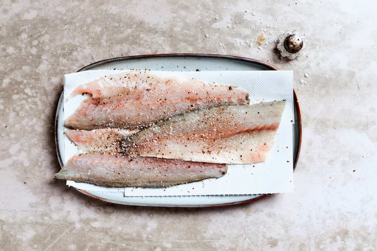 raw branzino fillets with salt and pepper.