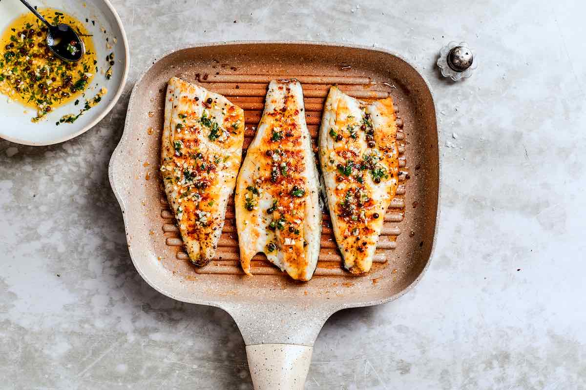 grilled branzino with garlic peppercorn sauce on top.