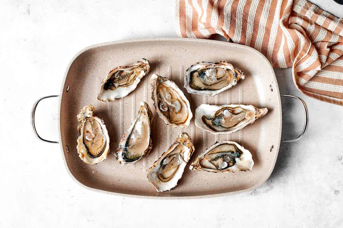 raw oysters on a grill pan.