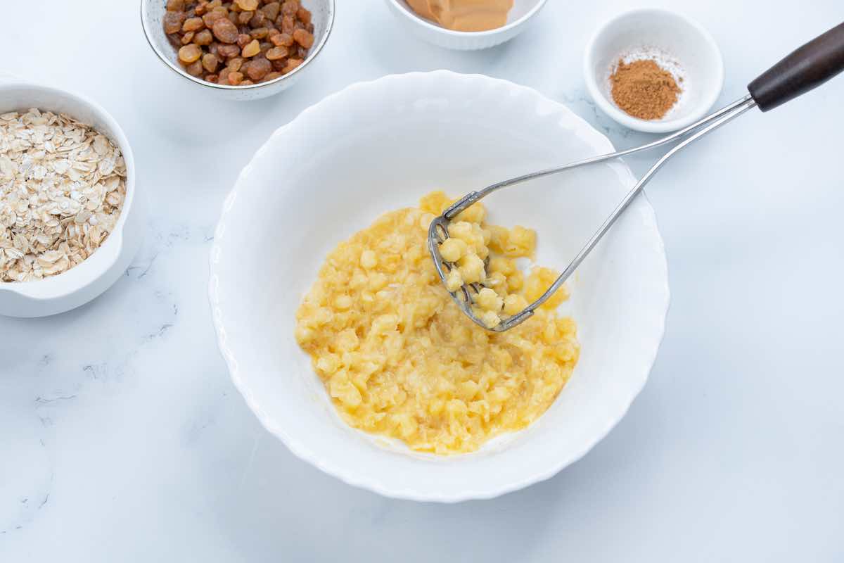 mashing bananas in a large mixing bowl.