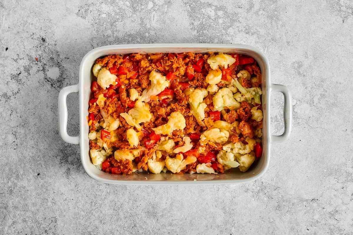 sauteed vegetables and sausage in a baking dish.