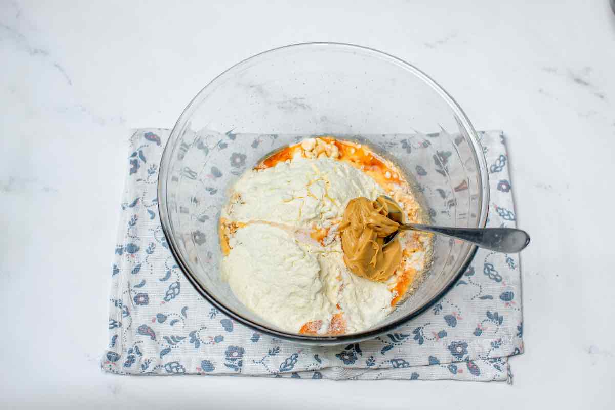 protein powder, oats, almond butter, and maple syrup in a bowl.