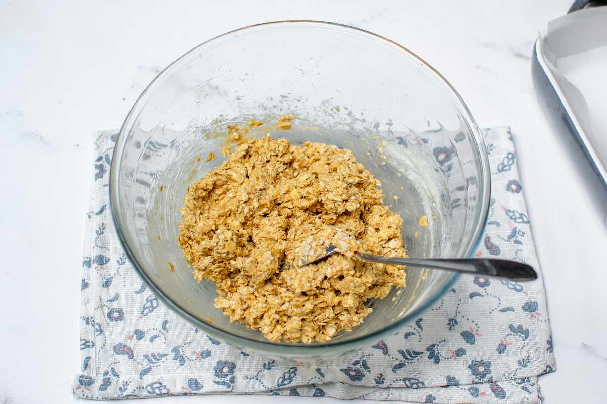 oats, protein powder, almond butter, and maple syrup in a bowl.