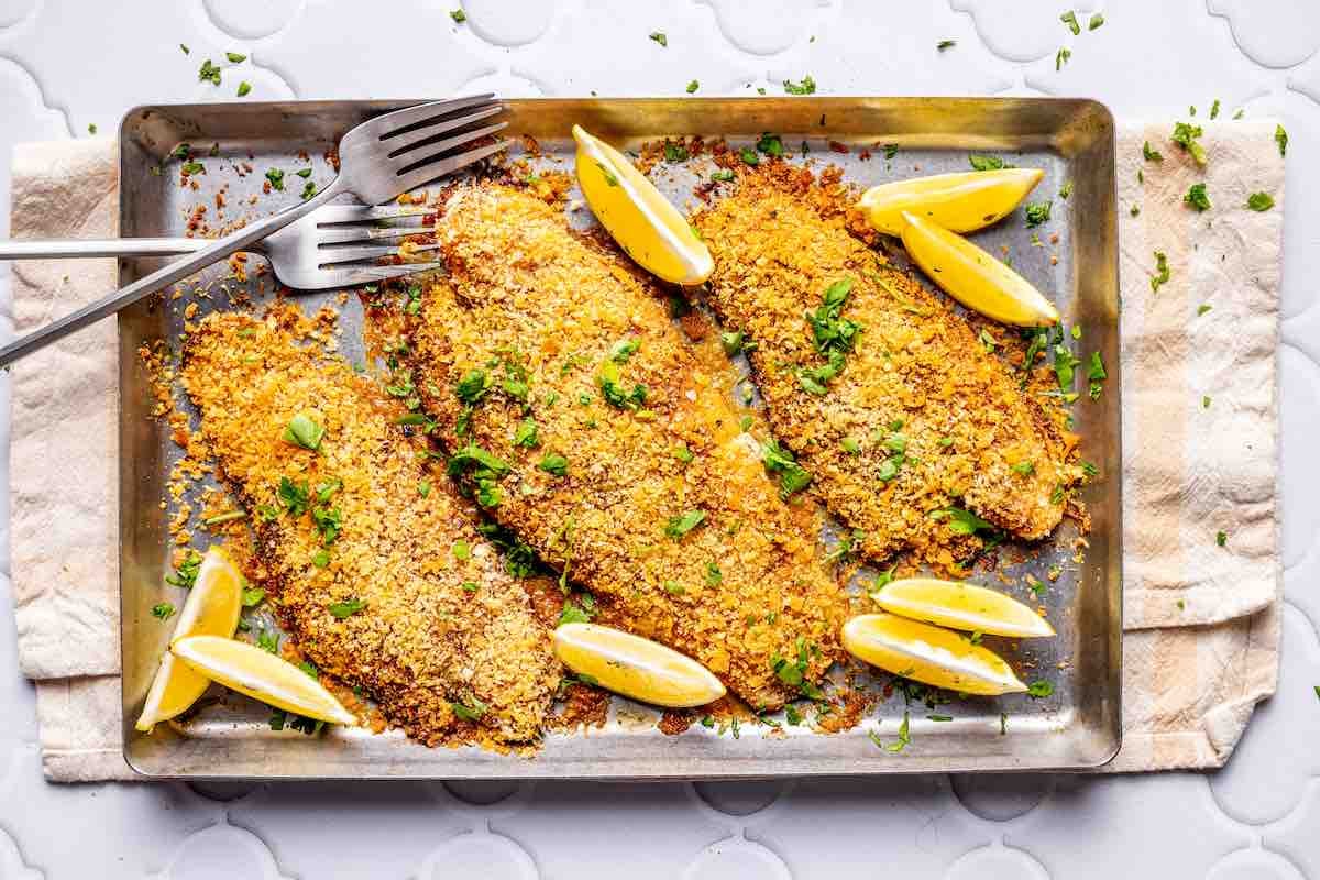 baked parmesan crusted tilapia on a baking sheet.