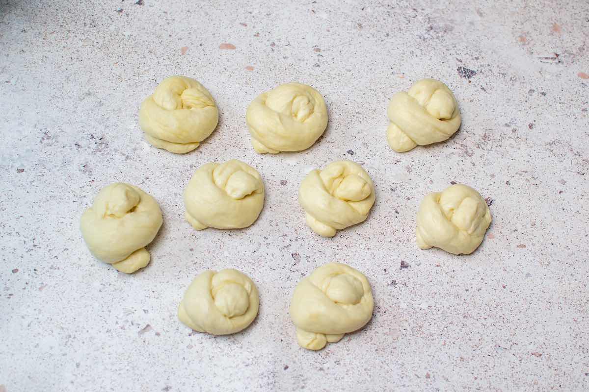 knotted dough balls on a floured surface.
