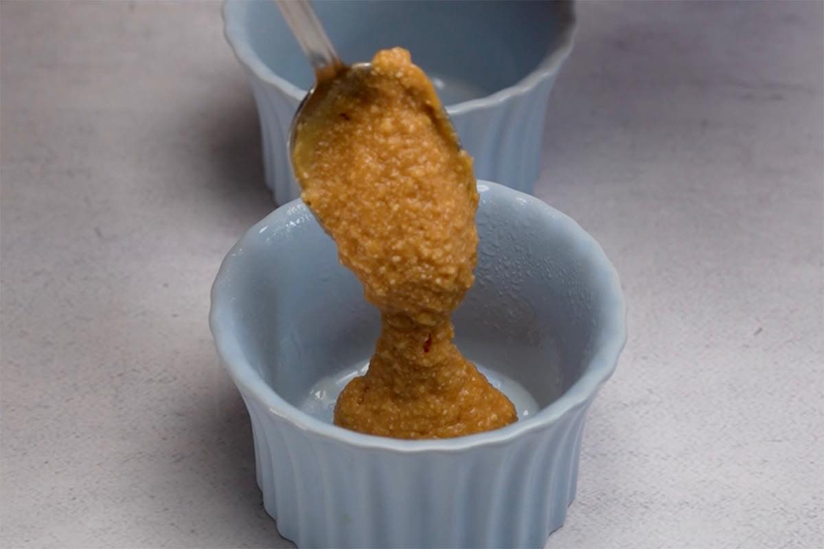 adding batter into two mugs.