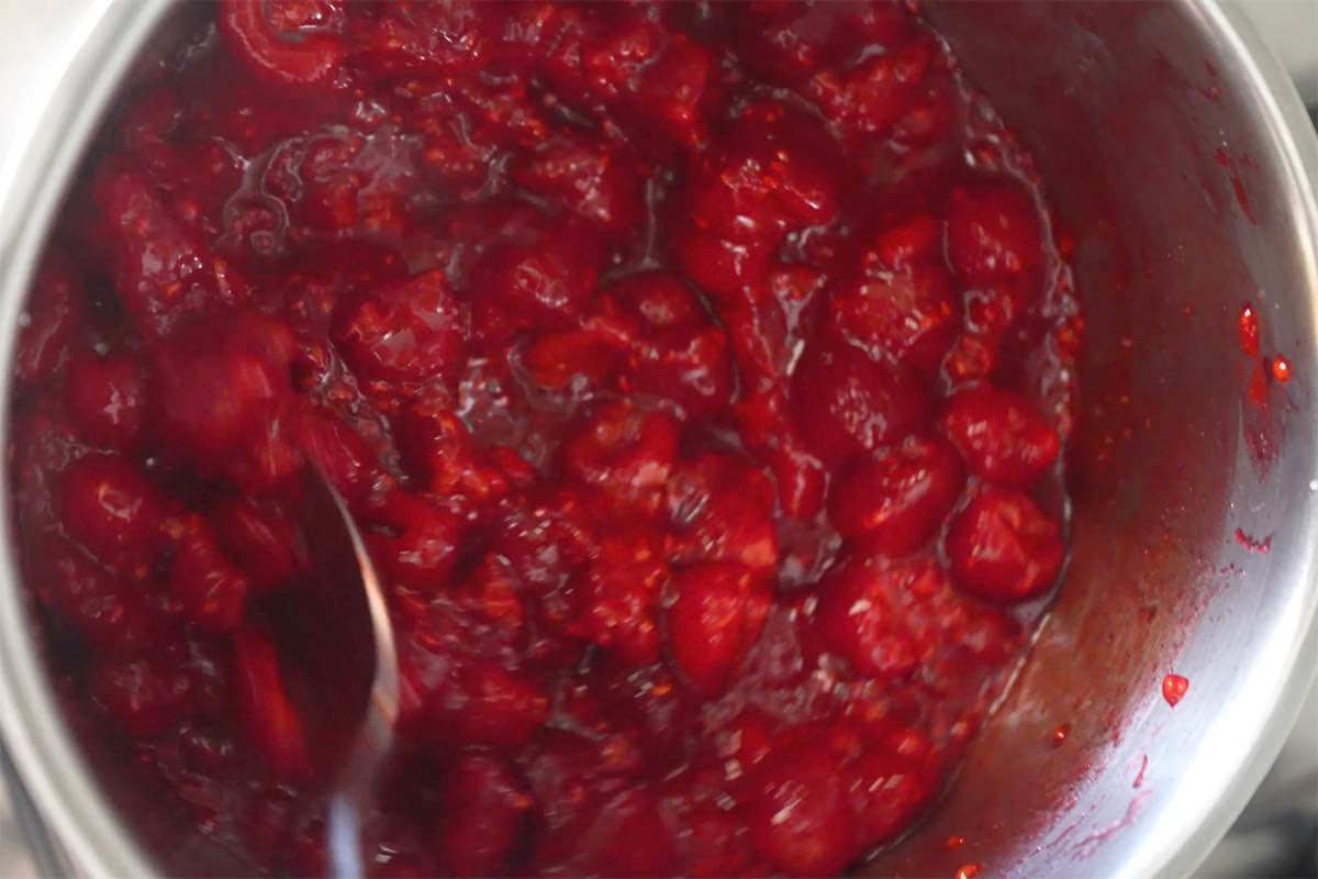 raspberries and sugar simmering in a saucepan.