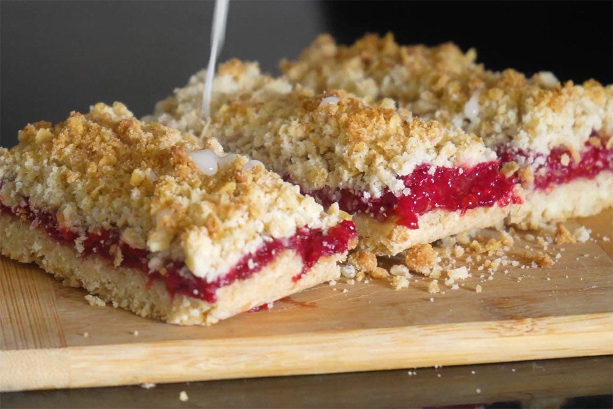 drizzling glaze over raspberry bars.