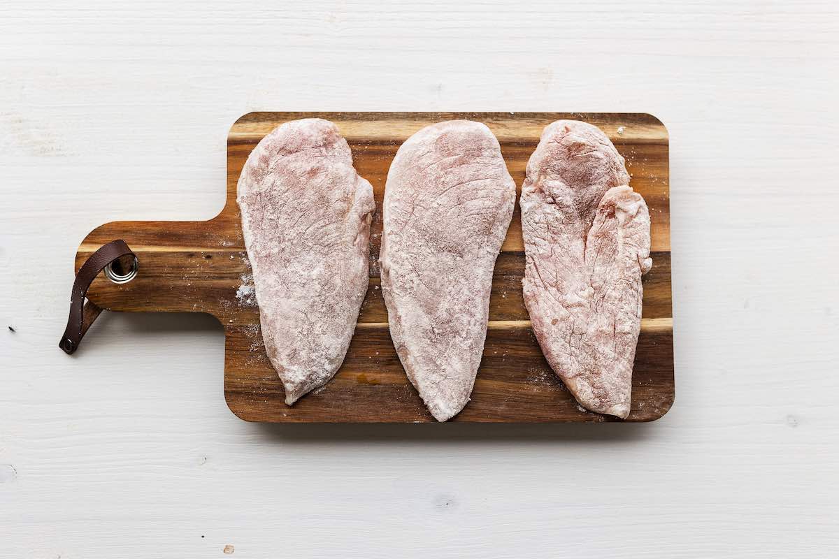 seasoned raw chicken breasts with flour, salt, and pepper. 
