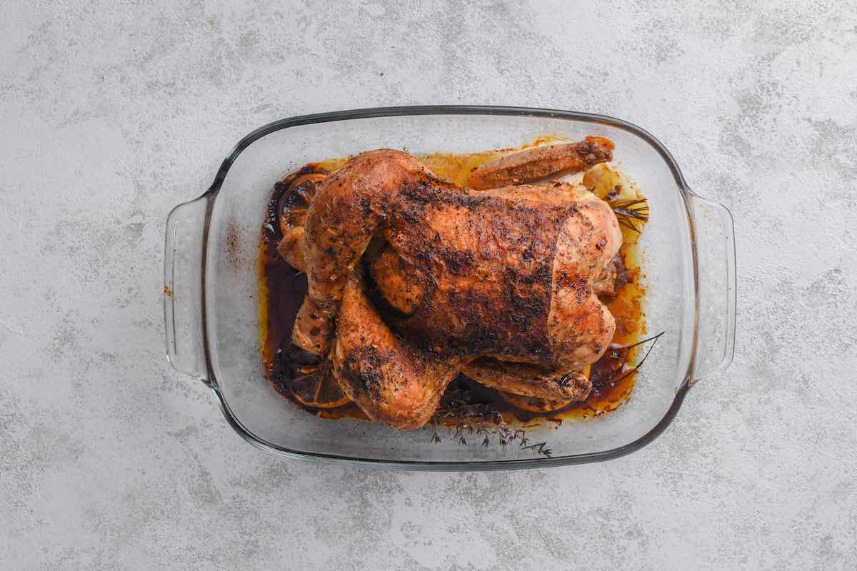 roasted cornish game hen in a baking dish.