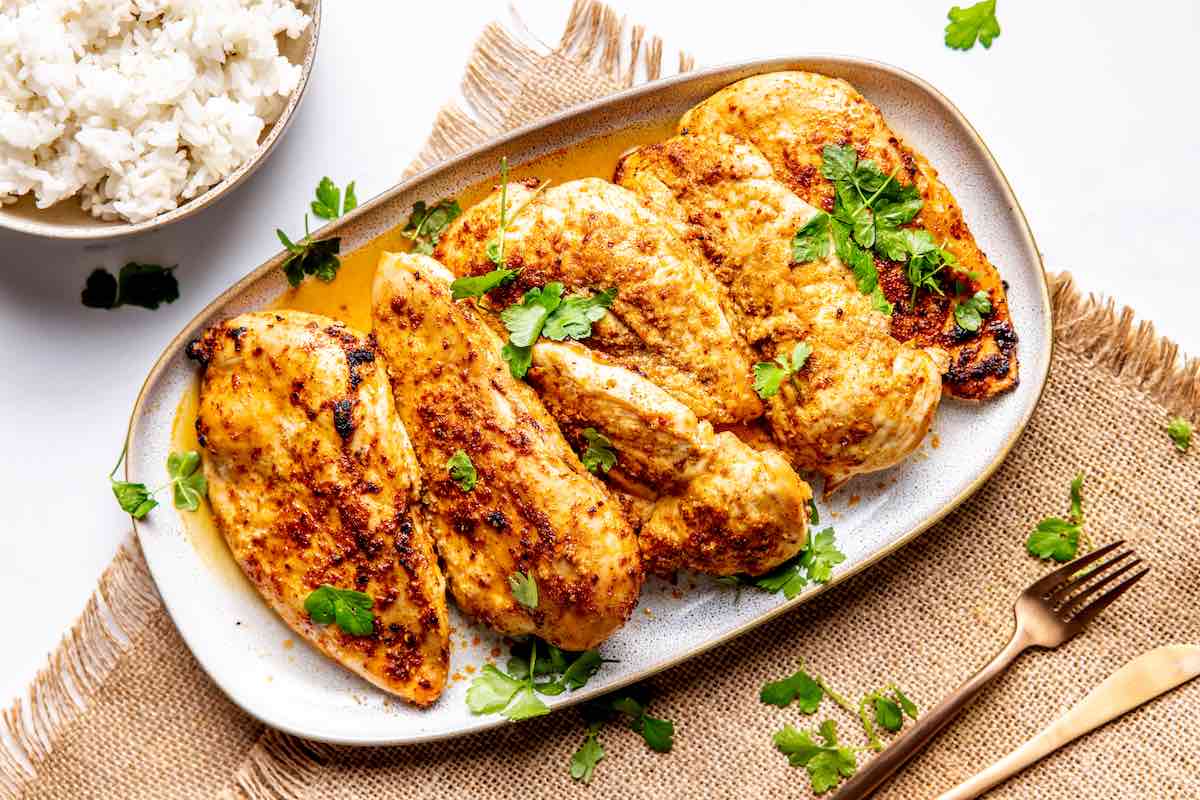 smoked chicken breasts on a serving plate.