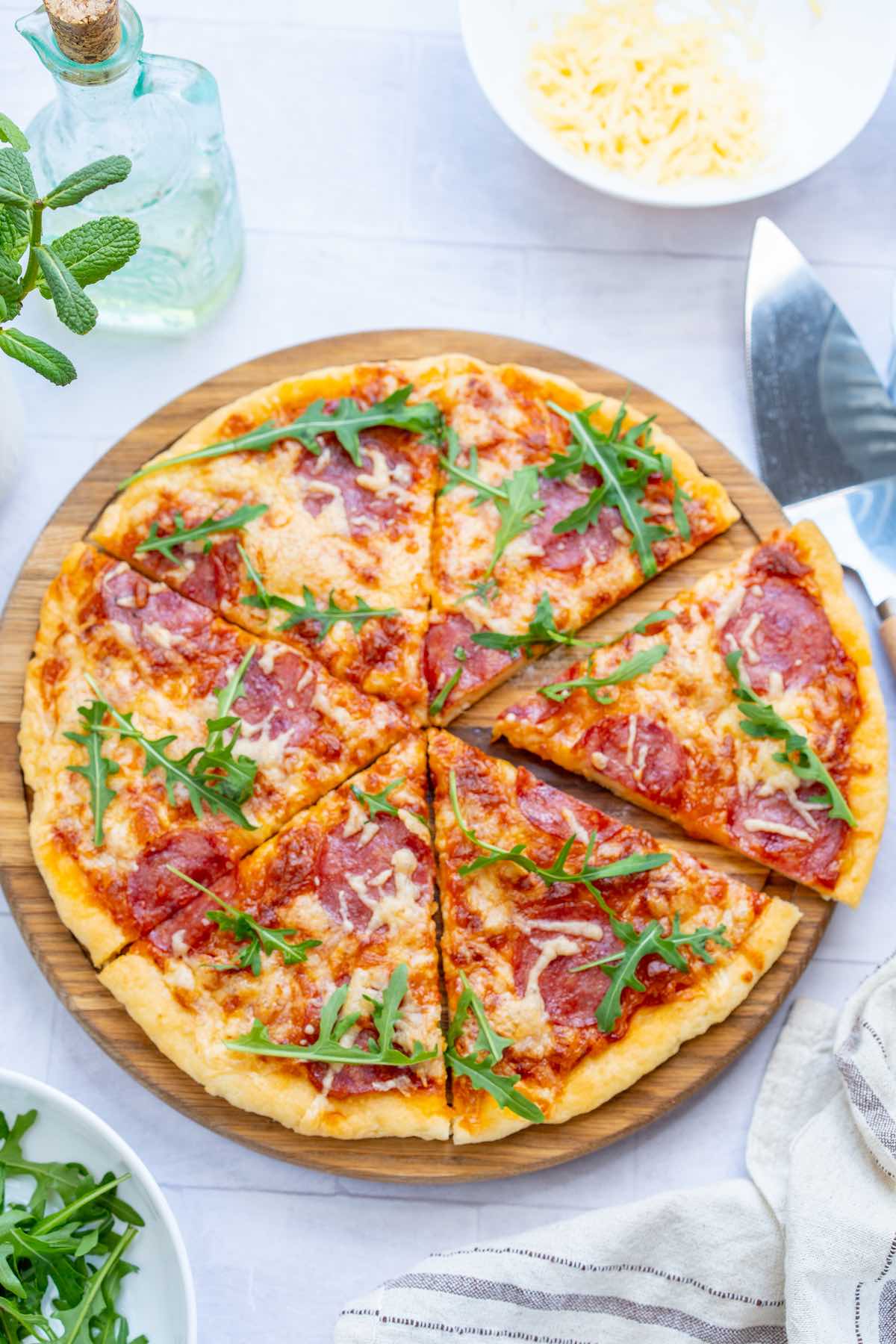 paleo pizza with arugula, cheese, and pepperoni.