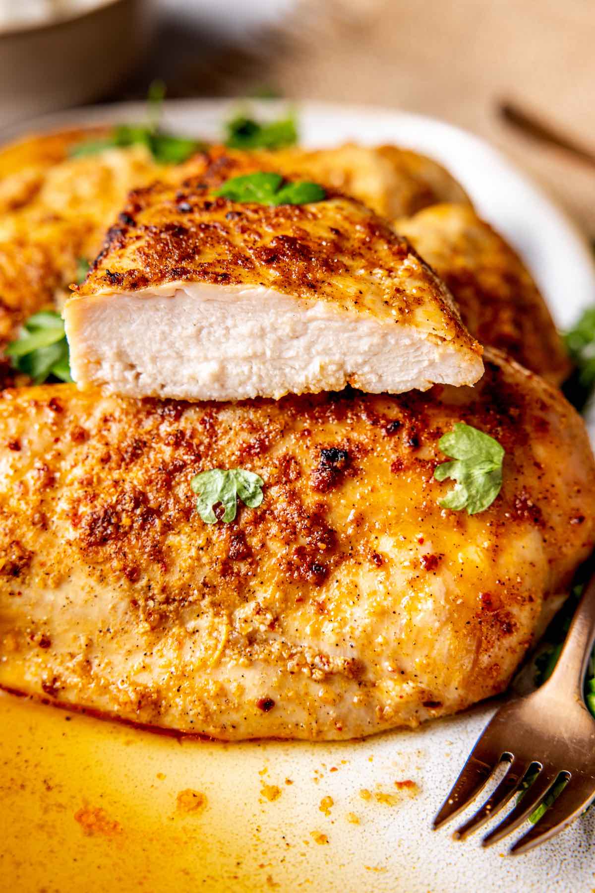 smoked chicken breast sliced in half to show the juicy texture.