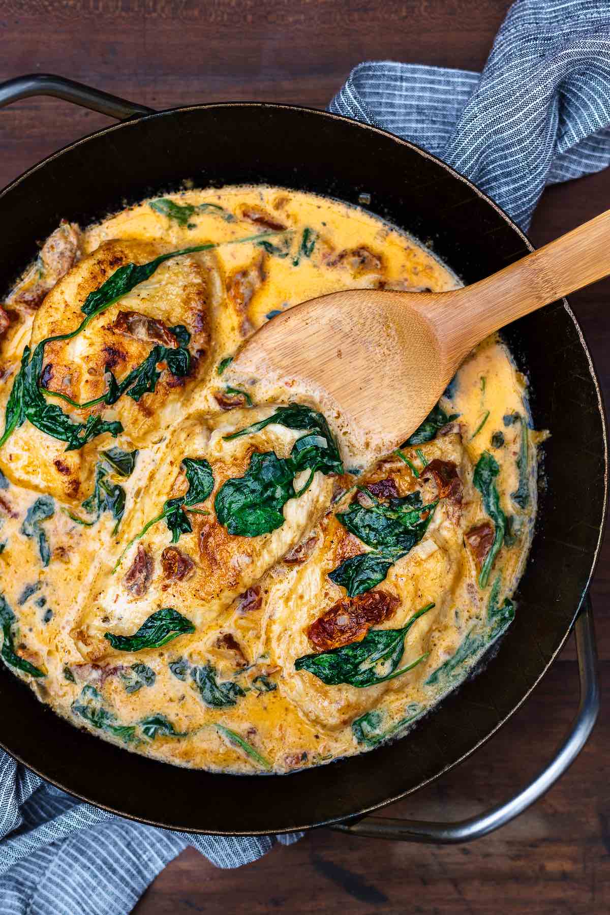 Tuscan chicken with creamy sauce in a skillet. 