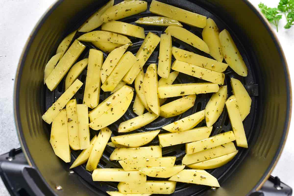 raw fries in the air fryer basket.