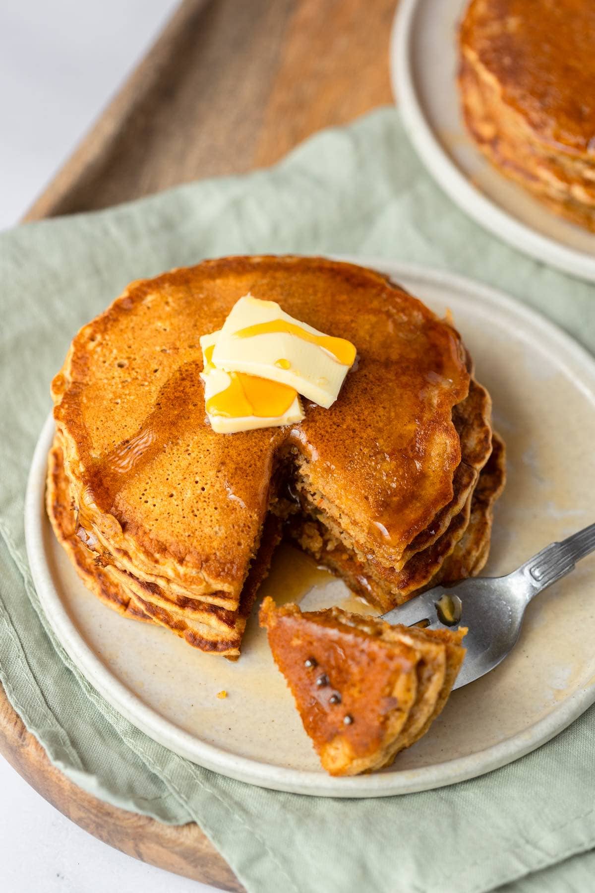 stack of healthy pumpkin pancakes with a pat of butter on top.