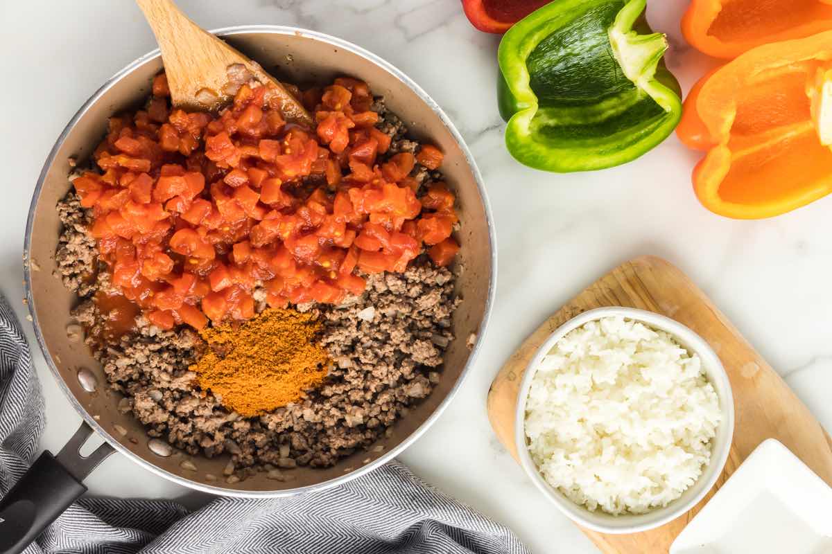 chopped tomatoes, ground beef, taco seasoning in a skillet.