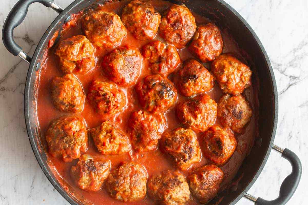 simmering meatballs in marinara sauce.