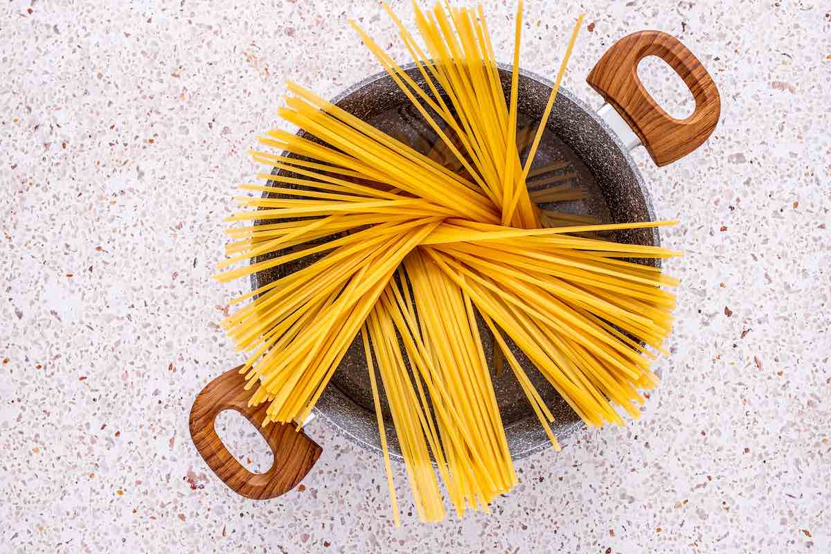 linguine cooking in a pot of boiling water.