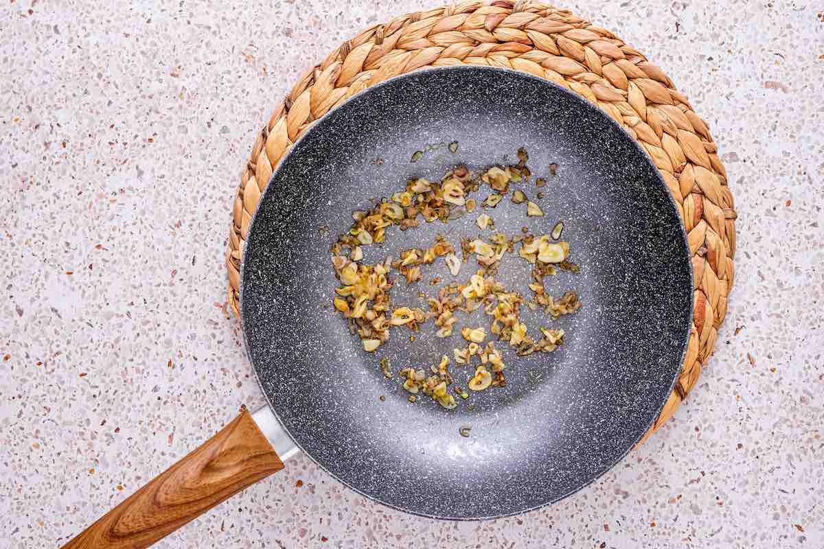 onion and garlic sauteing in a skillet.