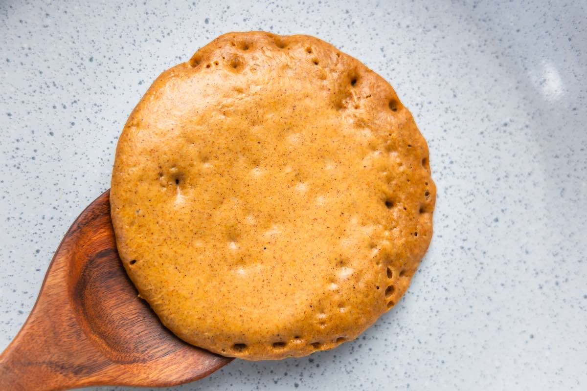 frying pumpkin protein pancakes in a skillet.