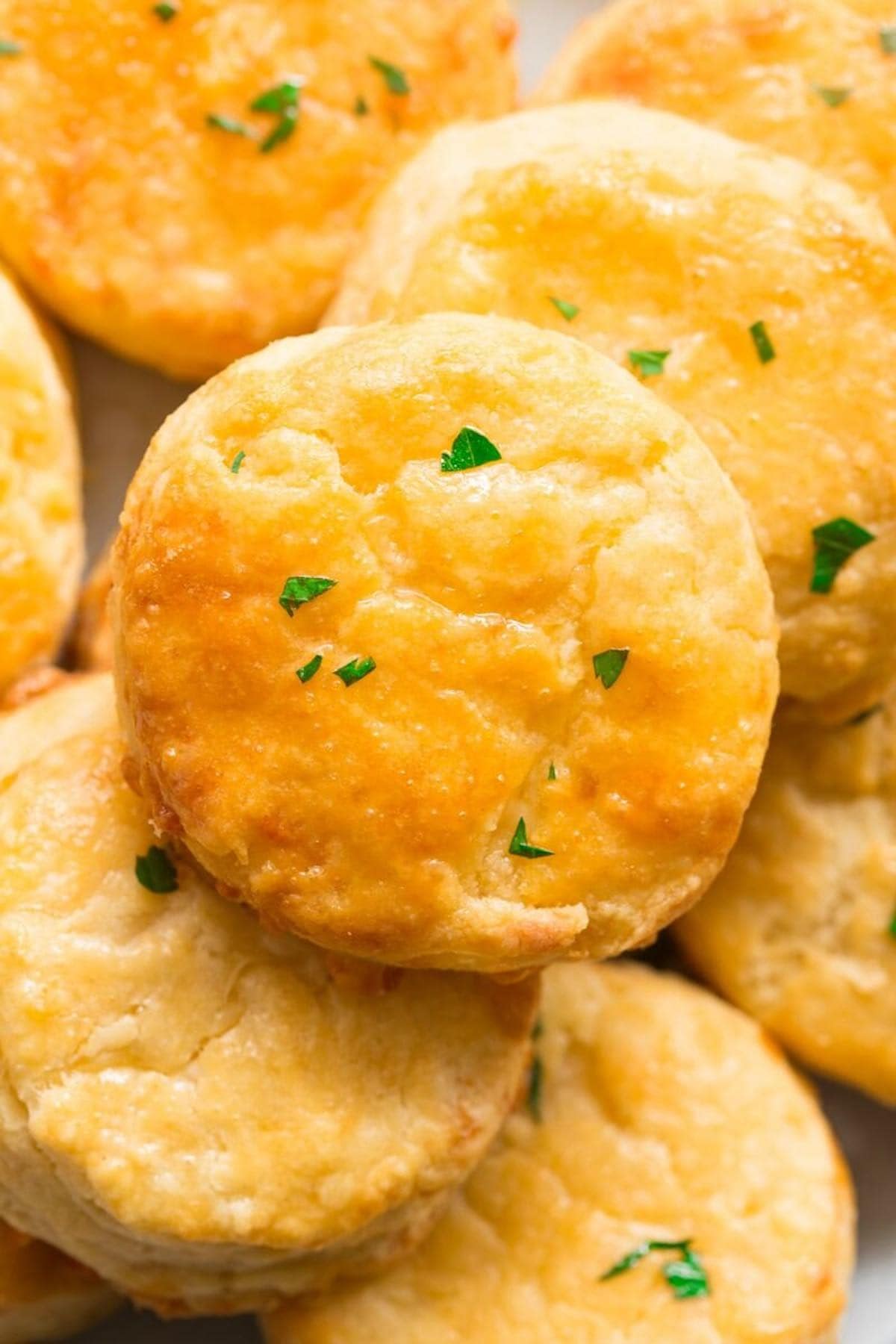 keto biscuits recipe on a plate with fresh herbs on top.