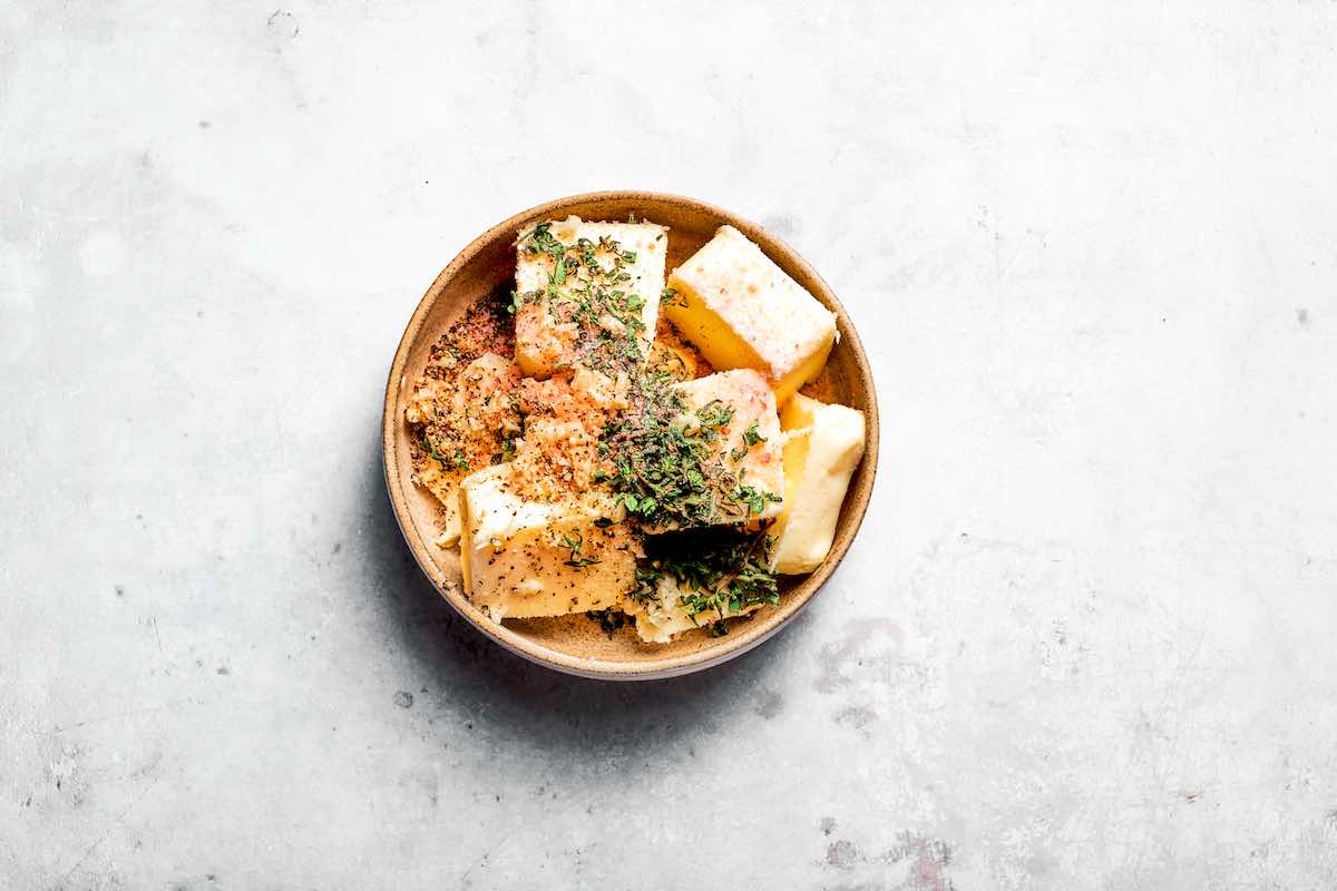 butter, garlic, herbs, salt, and pepper, in a bowl.