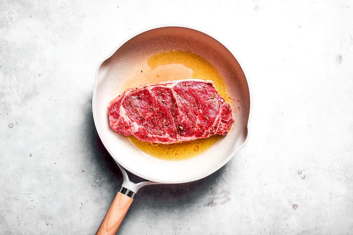 pan-searing shoulder steak in a skillet.