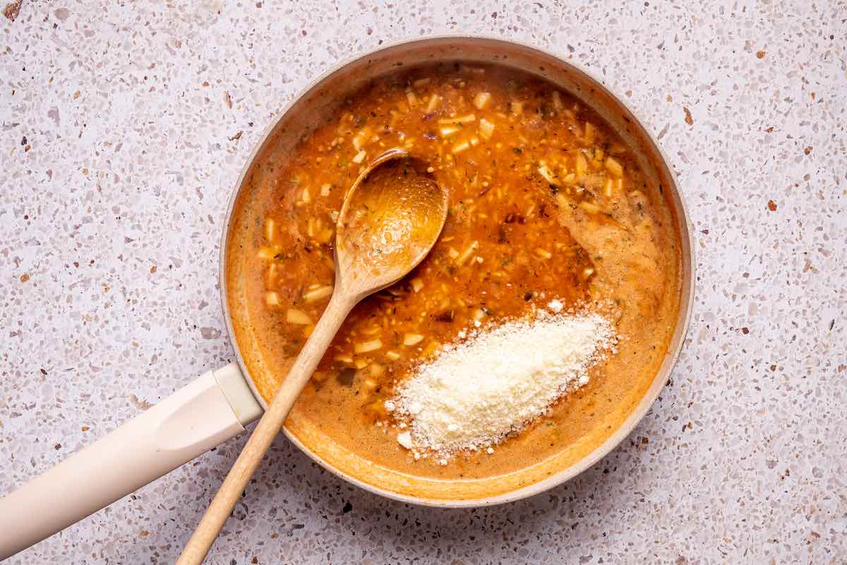 stuffed tomato mixture in a skillet with parmesan cheese.