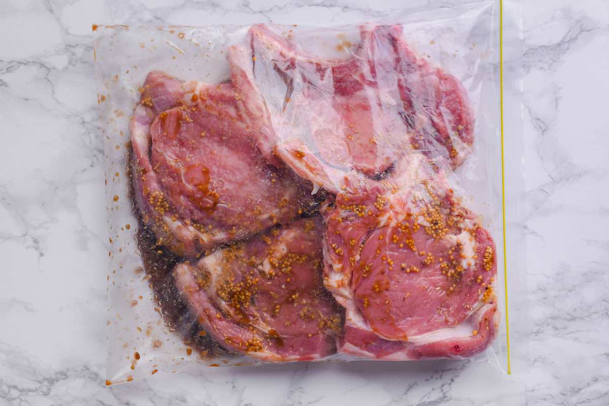raw veal chops in a ziplock bag with marinade.