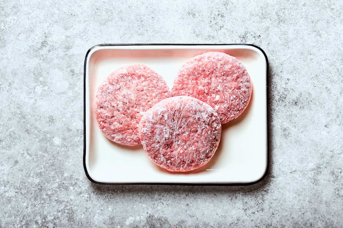 frozen hamburger patties on a plate.